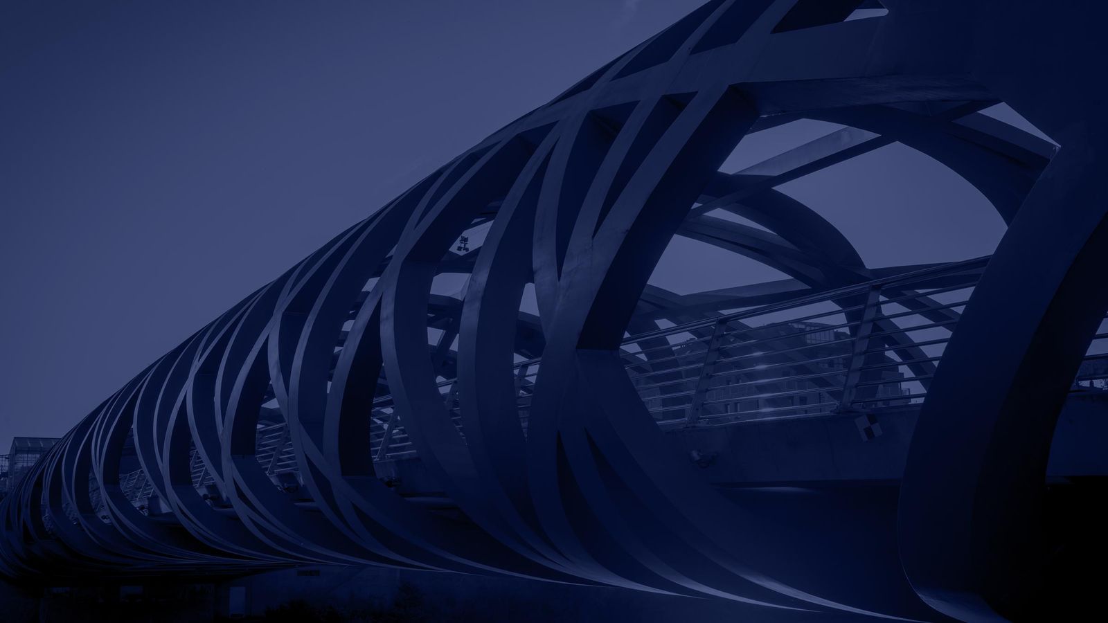 Pont Hans-Wilsdorf à Genève : arceaux d’acier entrelacés sous un ciel bleu nuit